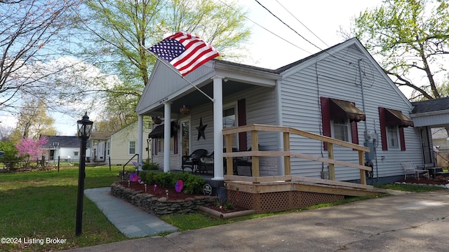 view of front of property with covered porch, fence, and a front lawn