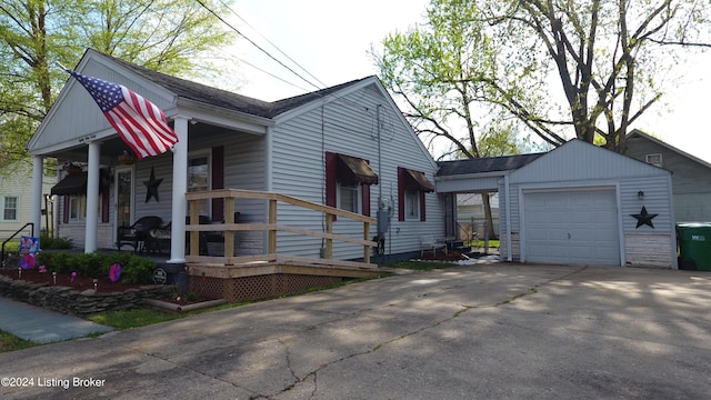 view of front facade with covered porch, an outbuilding, and a garage