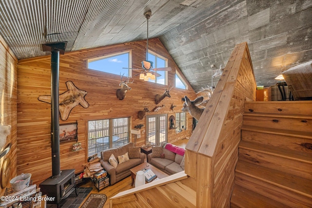 1478 Robbin Ln, Cub Run, KY 42729 - unfurnished living room featuring a wood stove, high vaulted ceiling, wooden walls, ceiling fan, and wood finished floors