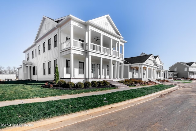 view of front of home with a porch, a balcony, and a front lawn