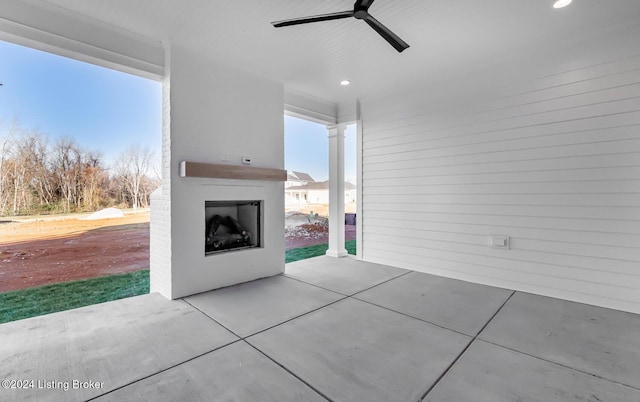 view of patio with ceiling fan and exterior fireplace