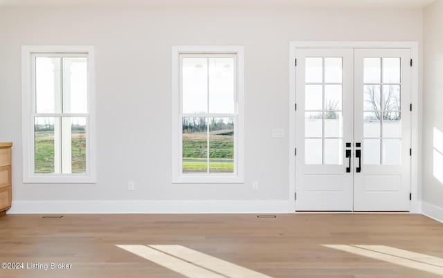 doorway to outside with plenty of natural light, french doors, and light hardwood / wood-style flooring