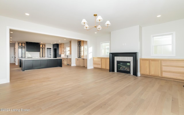 unfurnished living room featuring light hardwood / wood-style floors and a notable chandelier