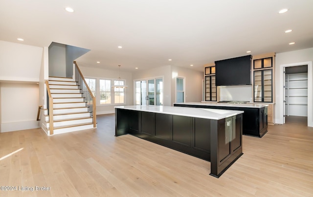 kitchen featuring pendant lighting, a spacious island, and light wood-type flooring