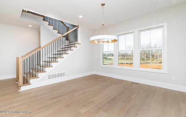 unfurnished dining area featuring hardwood / wood-style floors and a notable chandelier