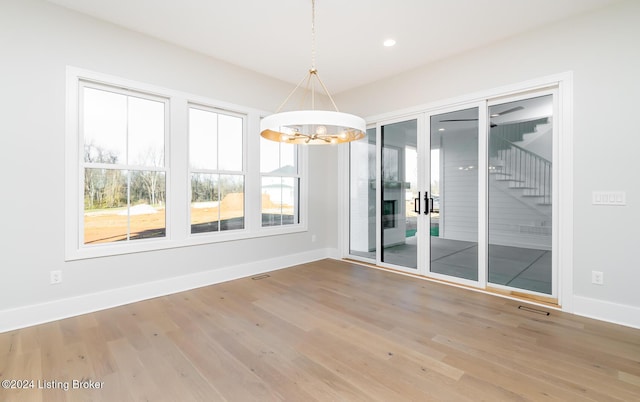 empty room featuring hardwood / wood-style flooring and a notable chandelier