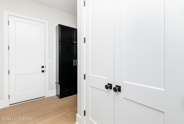 corridor with light hardwood / wood-style floors