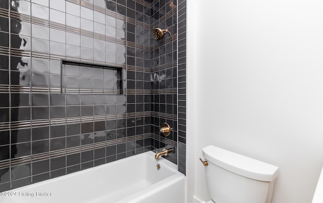 bathroom featuring tiled shower / bath combo and toilet