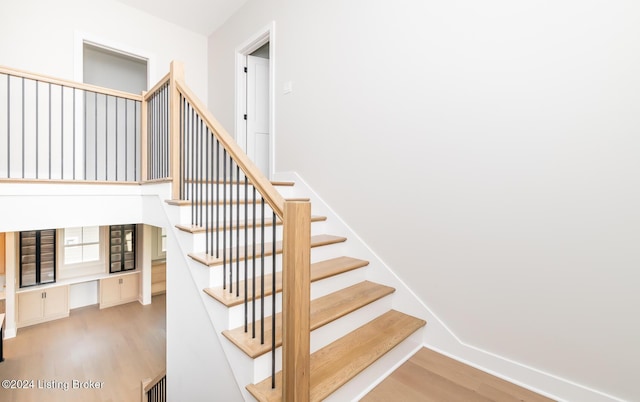 stairs featuring hardwood / wood-style floors and built in desk