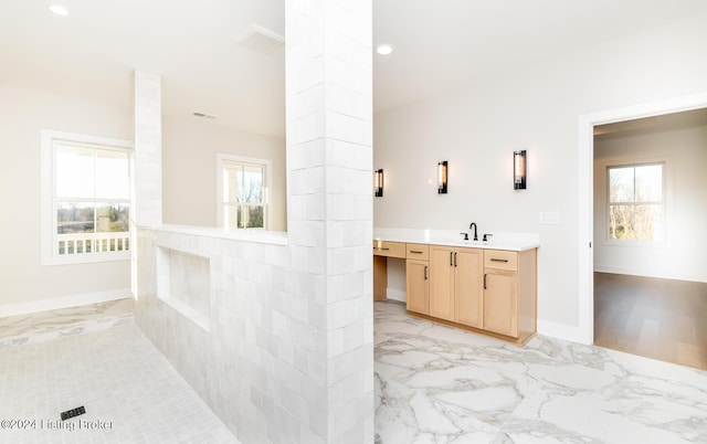 bathroom featuring vanity, ornate columns, and plenty of natural light