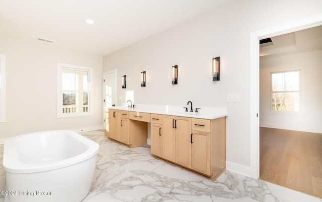 bathroom with wood-type flooring, vanity, and a tub to relax in