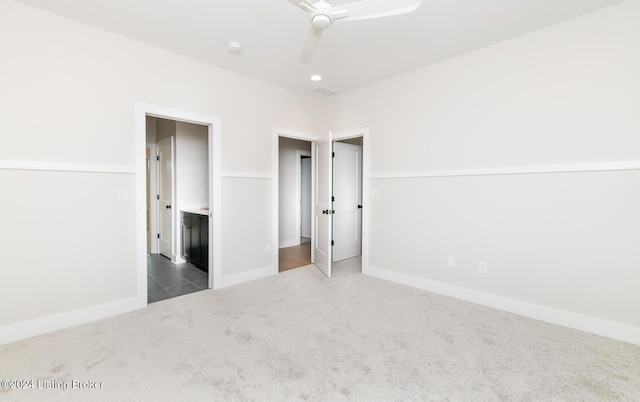 unfurnished bedroom featuring ceiling fan and dark carpet