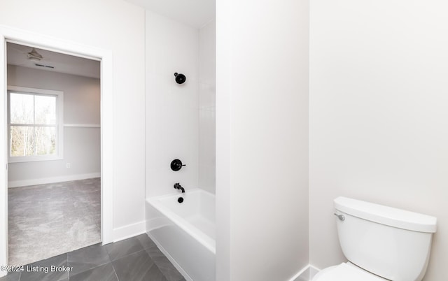 bathroom with tile patterned floors, tiled shower / bath combo, and toilet