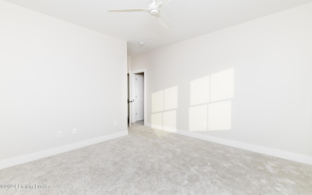 empty room featuring ceiling fan and light colored carpet