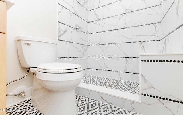 bathroom with tiled shower and toilet