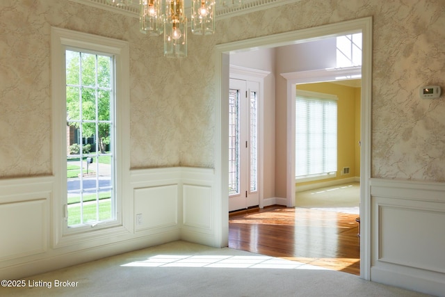 9602 Moorfield Cir, Louisville, KY 40241 - unfurnished dining area with a wainscoted wall, a chandelier, wood finished floors, a decorative wall, and carpet