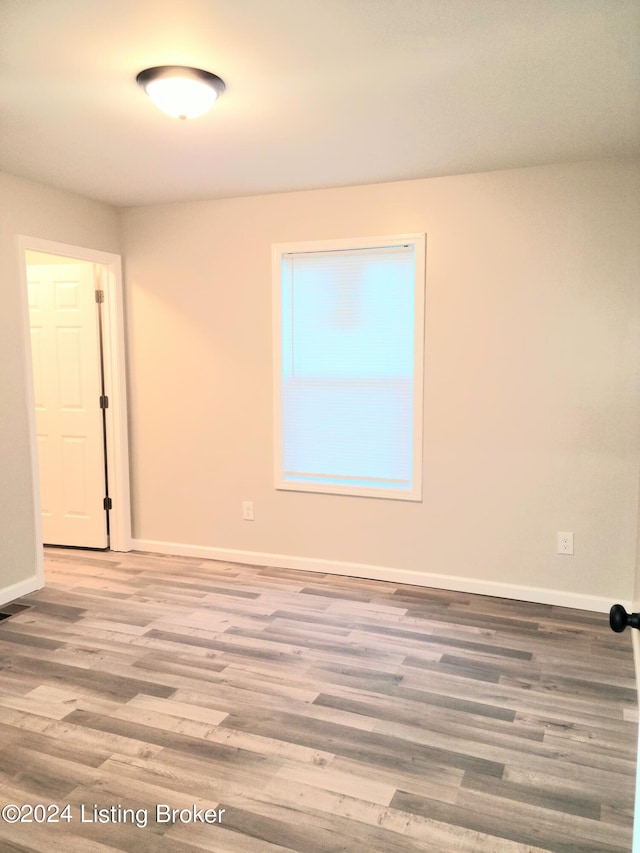 unfurnished room with hardwood / wood-style flooring