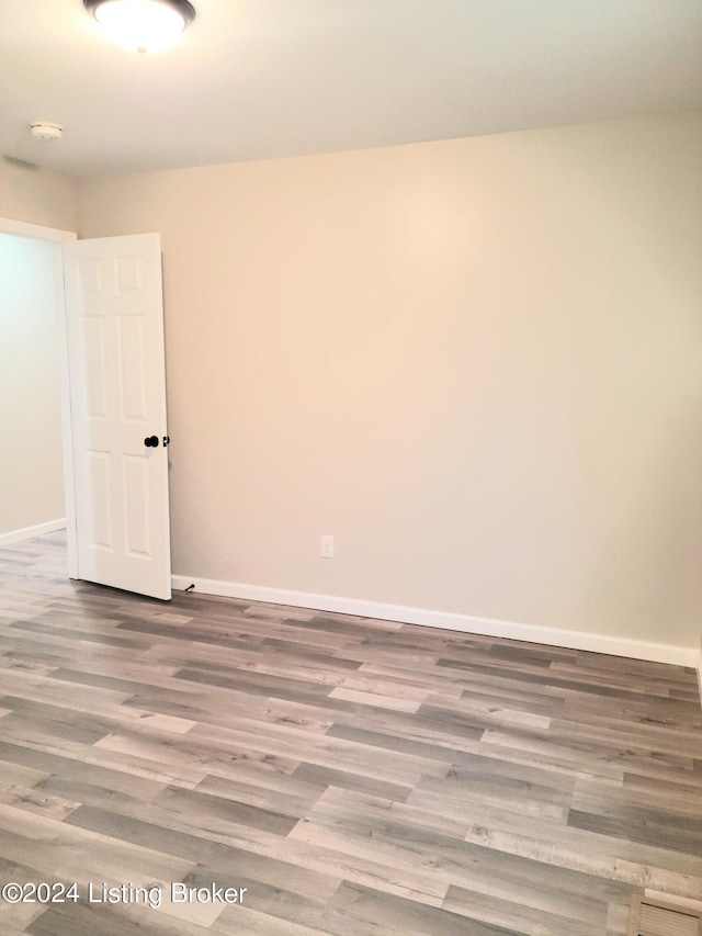 unfurnished room with hardwood / wood-style flooring