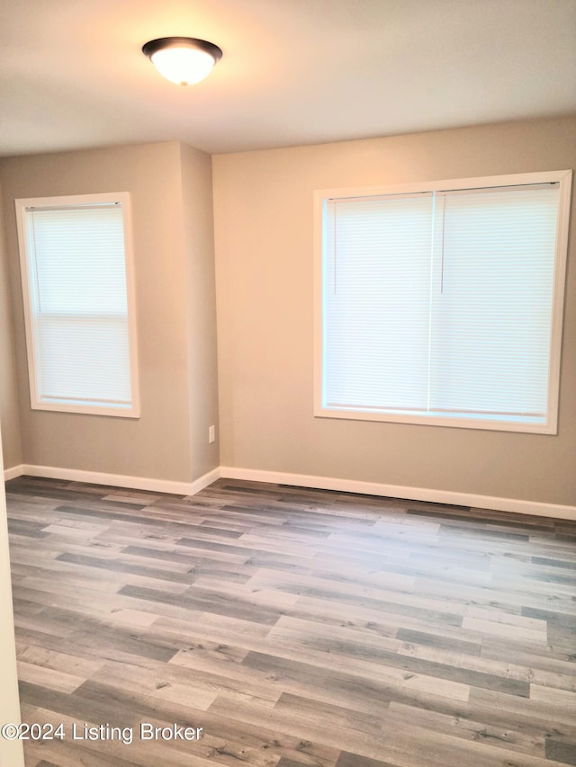 unfurnished room with hardwood / wood-style flooring and a healthy amount of sunlight