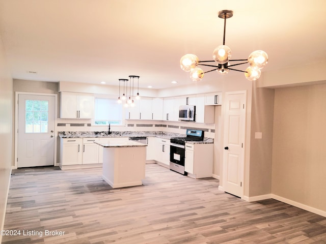 kitchen featuring white cabinets, appliances with stainless steel finishes, light hardwood / wood-style floors, and a kitchen island