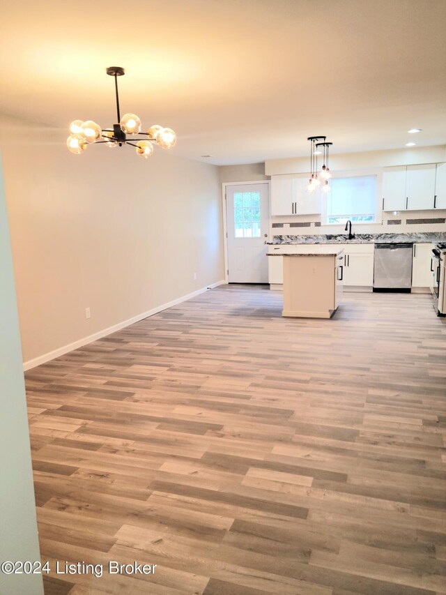 kitchen with light hardwood / wood-style floors, sink, white cabinets, hanging light fixtures, and stainless steel appliances