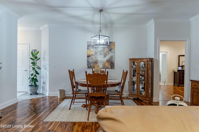 dining space featuring hardwood / wood-style floors, an inviting chandelier, and crown molding