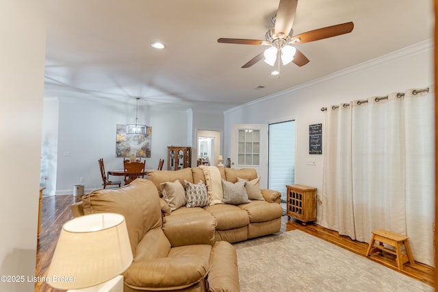 living room featuring ceiling fan, hardwood / wood-style floors, and ornamental molding