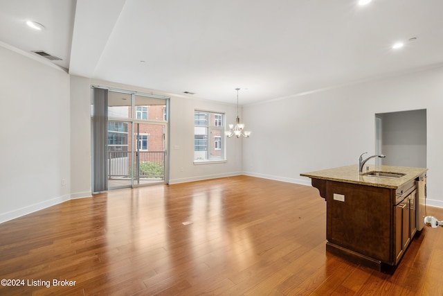 interior space with sink, an inviting chandelier, hardwood / wood-style floors, and ornamental molding