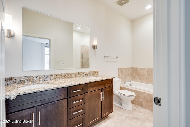 bathroom with tile flooring, tiled bath, toilet, and dual bowl vanity