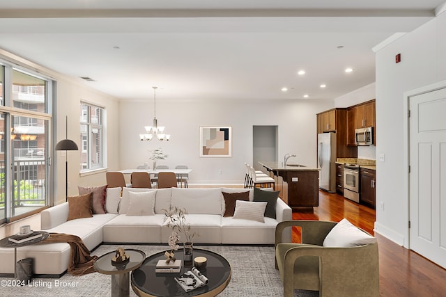 living room featuring sink, a chandelier, and hardwood / wood-style flooring