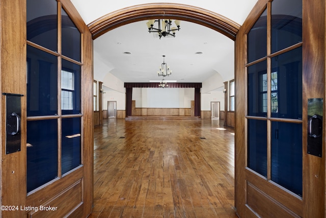 hall with a chandelier and wood-type flooring