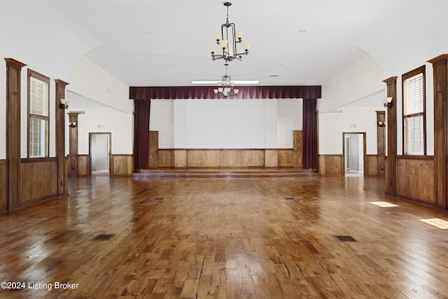 unfurnished living room featuring a chandelier and dark wood-type flooring