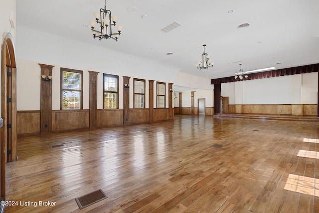 spare room with a notable chandelier and hardwood / wood-style flooring