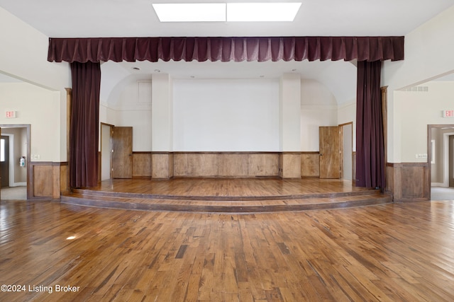 unfurnished living room featuring a skylight and hardwood / wood-style flooring