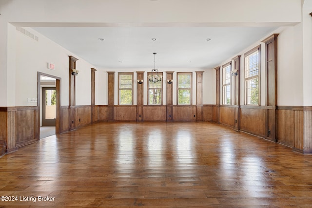 empty room with a healthy amount of sunlight and dark wood-type flooring