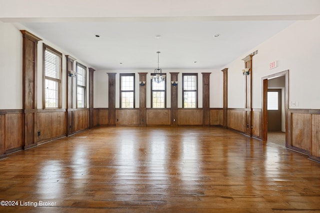 empty room featuring dark hardwood / wood-style floors and a notable chandelier