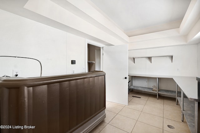 miscellaneous room with a tray ceiling and light tile flooring