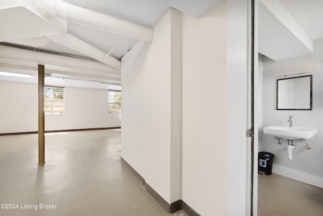 corridor featuring sink and concrete flooring