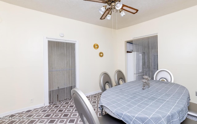 dining area featuring ceiling fan and a textured ceiling