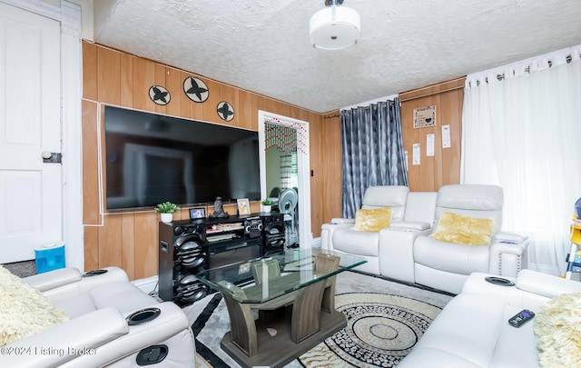 living room with a textured ceiling and wooden walls