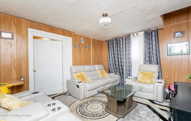 living room with a textured ceiling and wood walls