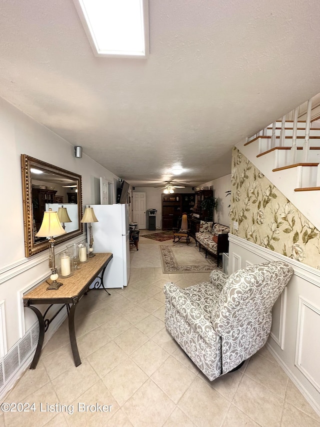 living room with a textured ceiling and light tile floors