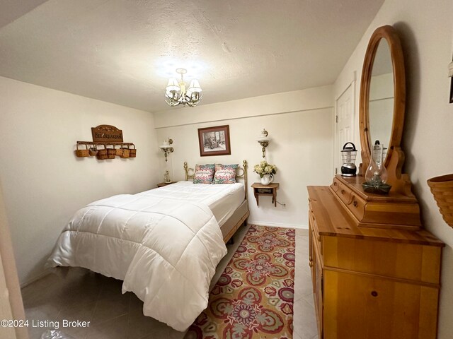 tiled bedroom featuring a chandelier