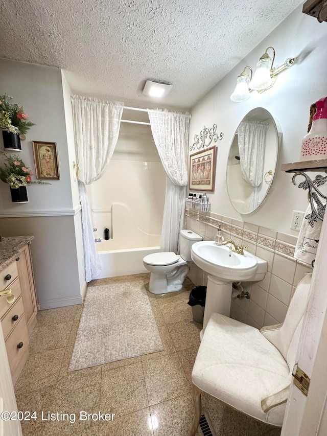 bathroom with tile walls, toilet, tile flooring, shower / bath combo, and a textured ceiling