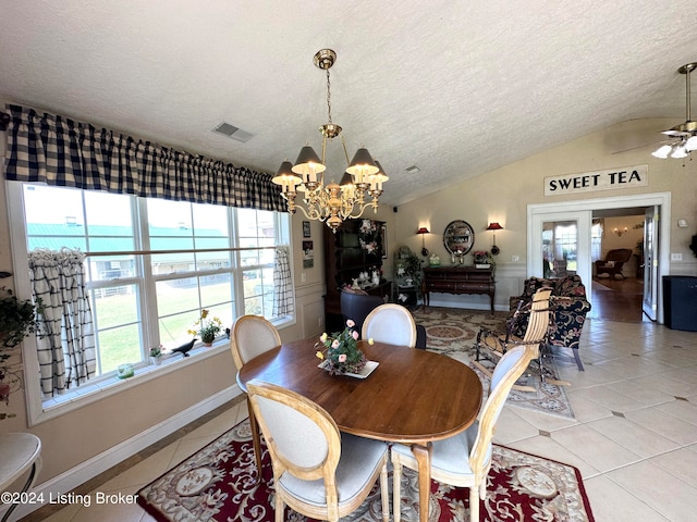 tiled dining room featuring a healthy amount of sunlight, vaulted ceiling, a textured ceiling, and ceiling fan with notable chandelier