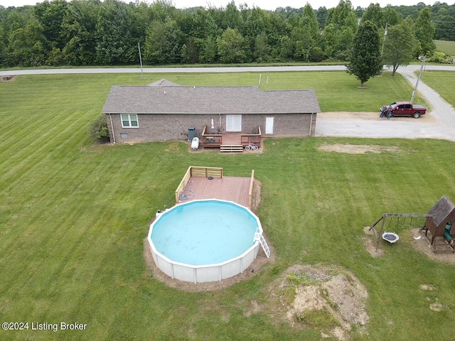 view of pool with a lawn and a wooden deck