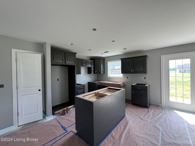 kitchen with gray cabinetry, a kitchen island, and a healthy amount of sunlight