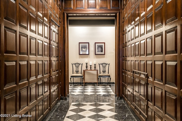 hall with dark tile flooring