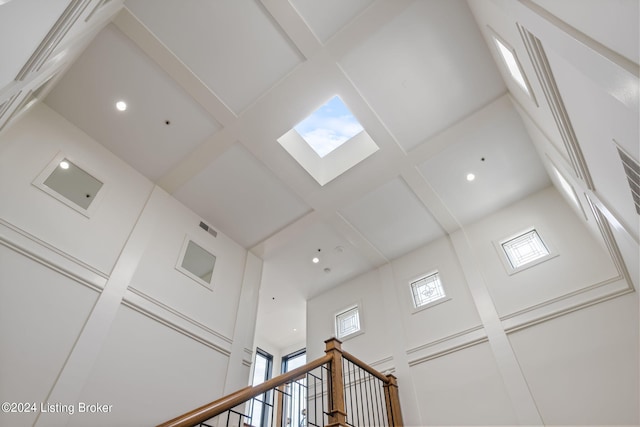 interior details featuring coffered ceiling and a skylight