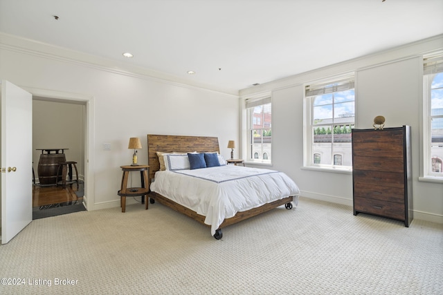 bedroom with light carpet and ornamental molding